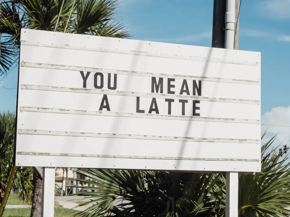 A coffee shop marquee sign reading You Mean A Latte, photographed for a client site
